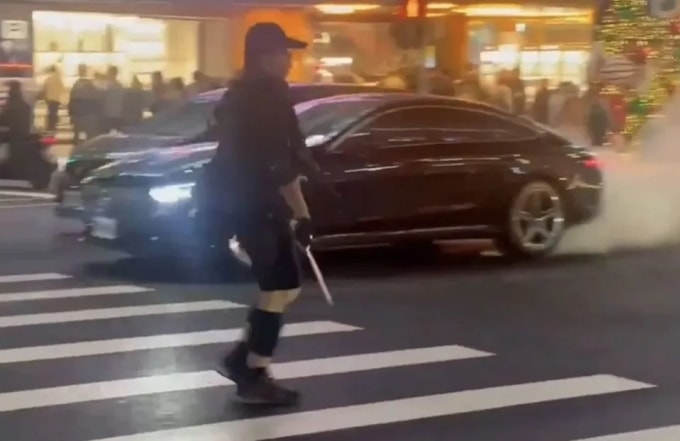 Nghi phạm Trương Văn cầm mã tấu đi lại trên đường phố Đài Bắc ngày 19/12. Ảnh: Innews