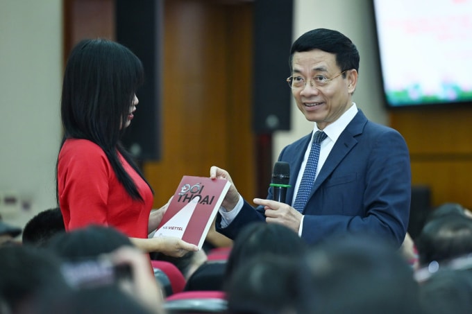 Bộ trưởng Nguyễn Mạnh Hùng tặng sách cho cán bộ đặt câu hỏi. Ảnh: Giang Huy