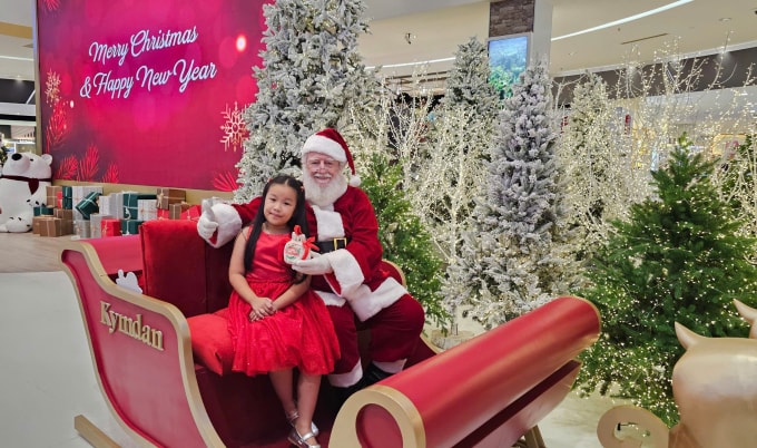 Một em nhỏ chụp ảnh và nhận quà từ ông già Noel. Ảnh: Kymdan