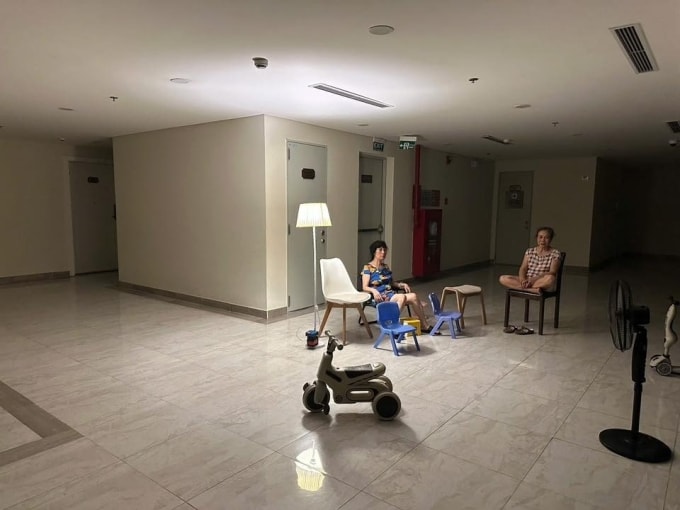 Một gia đình ở chung cư Hà Nội ra hành lang ngồi hóng mát khi cả tòa nhà mất điện giữa ngày hè, tháng 6/2024. Ảnh: PD