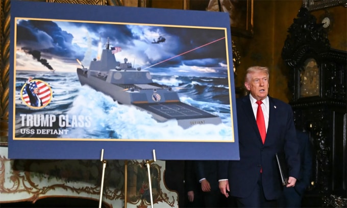 Tổng thống Mỹ Donald Trump đứng cạnh đồ họa mô phỏng chiến hạm USS Defiant tại dinh thự Mar-a-Lago, bang Florida ngày 22/12. Ảnh: AFP