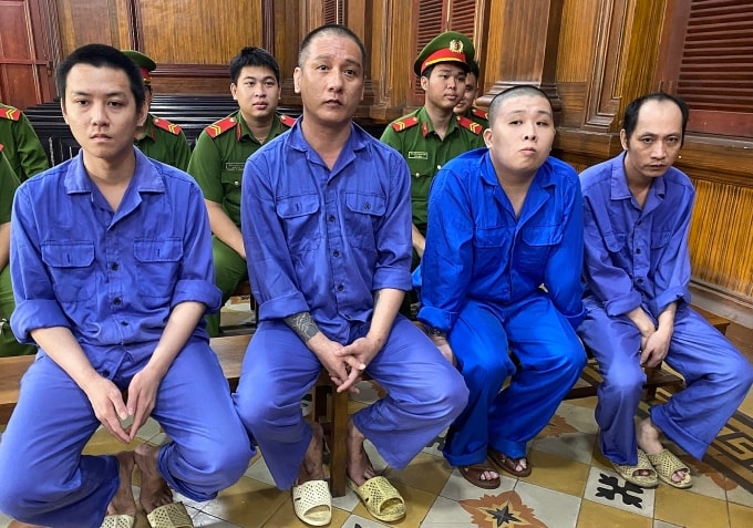 Bị cáo Trần Thanh Hiếu (ngoài cùng bên phải) và Nguyễn Văn Xành (ngoài cùng bên trái) cùng đồng phạm tại tòa. Ảnh: Hải Duyên
