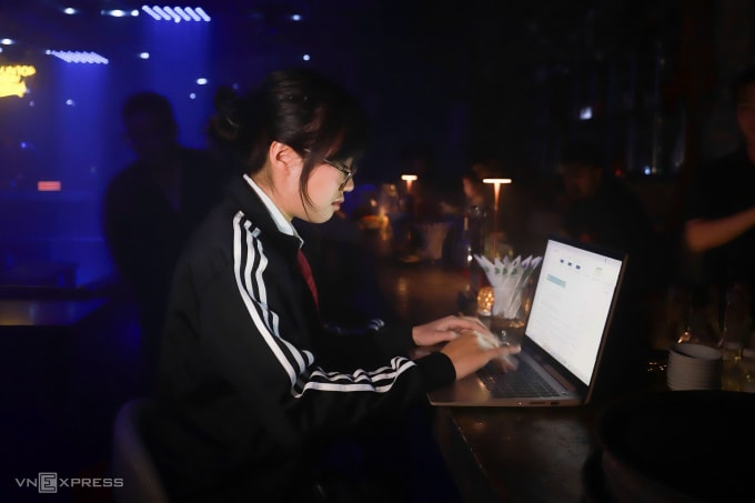 Khánh Ngân, 21 tuổi, phường Nam Từ Liêm đang chạy deadline ở quán bar, tối 20/12. Ảnh: Quỳnh Nguyễn