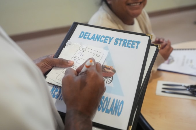 Nhân viên nhà hàng Delancey Street ghi lại yêu cầu món ăn của khách. Ảnh: AP