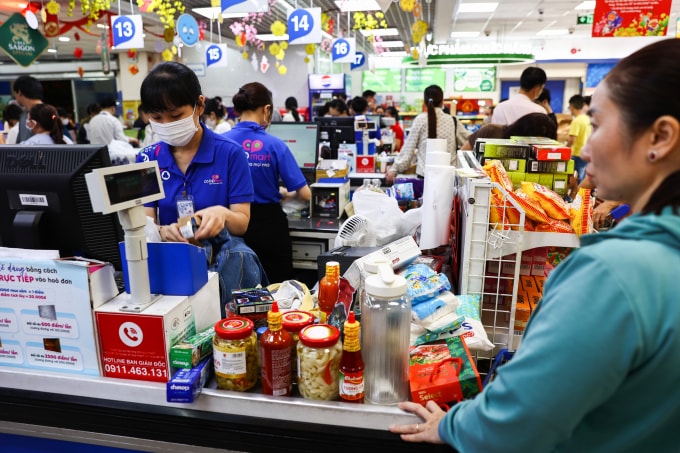 Người dân mua sắm hàng hoá tại siêu thị Co.opmart Thủ Đức, tháng 1/2025. Ảnh: Quỳnh Trần Lúc 20h, vào khung thời gian cao điểm trong ngày, hơn 20 quầy thanh toán tại hoạt động hết công suất. Khách phải xếp hàng chờ khoảng 15-20 phút mới tới lượt. Nhằm phục vụ nhu cầu mua sắm dịp Tết tăng cao, siêu thị tăng cường thêm khoảng 10 quầy thanh toán. Tôi mua chủ yếu bánh kẹo, thực phẩm chế biến sẵn, mứt với hoa đơn sơ sơ gần 4 triệu mà vẫn chưa đủ. Chờ sắp tới được nghỉ Tết sẽ đi sắm thêm đồ, chị Mỹ Dung nói, trong lúc chờ tính tiền.