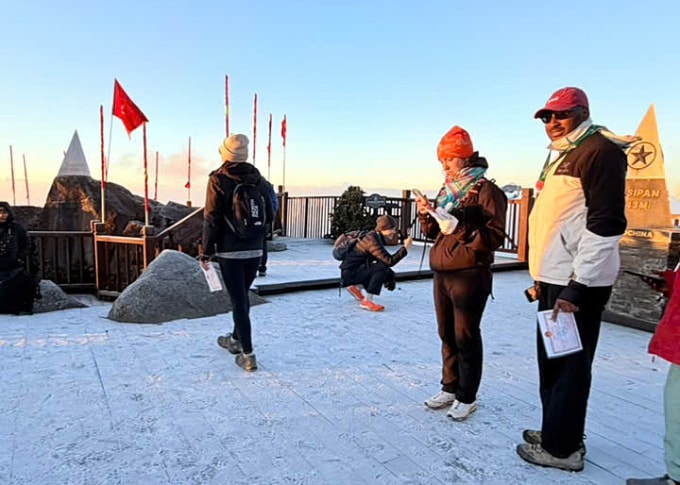 Du khách thích thú với băng giá trên đỉnh Fansipan, sáng 25/12. Ảnh: Lan Hương