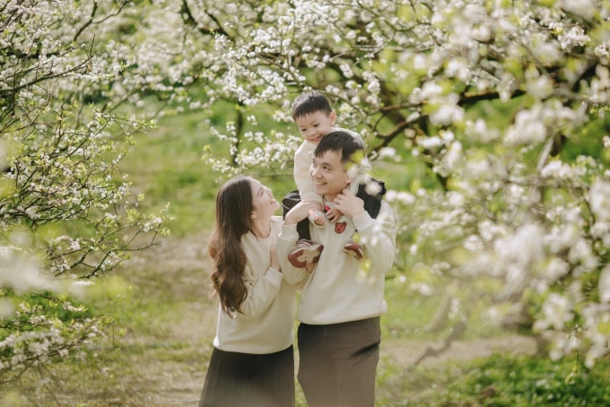 Khách du lịch chụp ảnh với hoa mận Mộc Châu giữa tháng 12. Ảnh: Lê Nguyên