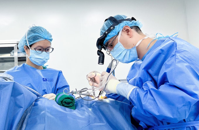 Bác sĩ Hữu (ngồi) đang mổ dẫn lưu áp xe cho bà An. Ảnh: Bệnh viện Đa khoa Tâm Anh