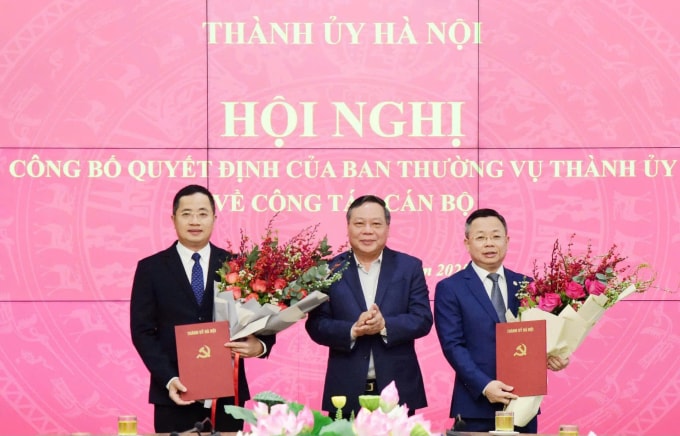Phó Bí thư Thường trực Thành ủy Hà Nội Nguyễn Văn Phong trao quyết định cho ông Trần Thanh Hà (bên phải) và ông Nguyễn Thành Long (bên trái), sáng 26/12. Ảnh: Viết Thành