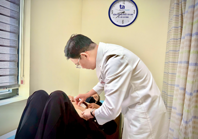 Bác sĩ Khánh kiểm tra vết mổ của bà Tứ trong ngày tái khám. Ảnh: Bệnh viện Đa khoa Tâm Anh