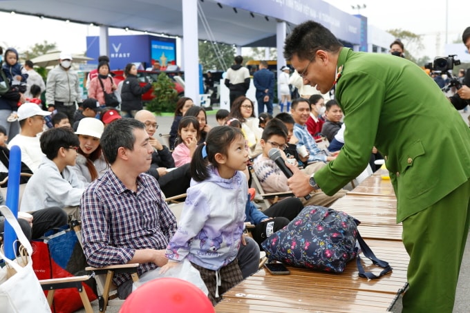 Thiếu tá Phạm Đăng Quý đặt câu hỏi cho trẻ tham gia workshop Thoát hiểm - thoát nạn trên xe. Ảnh: Lương Dũng