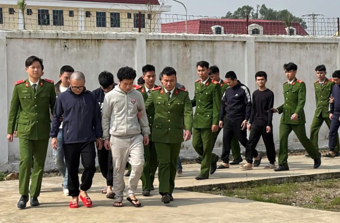 Cảnh sát dẫn giải các nghi phạm tới trại giam. Ảnh: Công an cung cấp