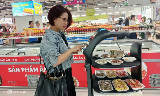 Khách hàng trải nghiệm sử dụng Robot tại Co.opmart Thống Nhất sáng 7/11. Ảnh: Thi Hà