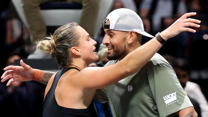 Kyrgios (phải) và Sabalenka ôm nhau trên lưới sau trận đấu nam - nữ tại sân Coca Cola, Dubai, UAE hôm 28/12. Ảnh: Reuters