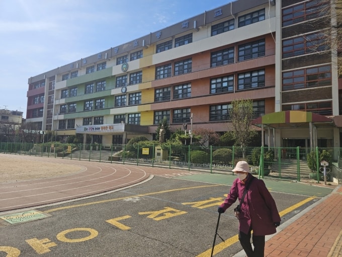 Một bà cụ tập thể dục trong khuôn viên trường tiểu học Hwayang (Seoul), nơi phải đóng cửa năm ngoái vì thiếu học sinh. Ảnh: The Korea Herald.