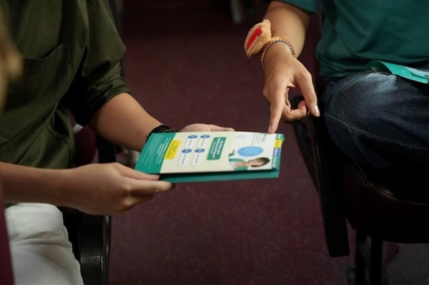 Các bạn trẻ tiếp cận thông tin về HPV qua tờ rơi. Ảnh: Phạm Thế Hiển