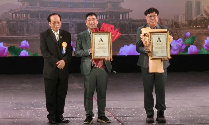 Từ trái qua: NSND Lê Tiến Thọ trao giải thưởng cho soạn giả Mai Văn Lạng và đạo diễn Thanh Hiệp.