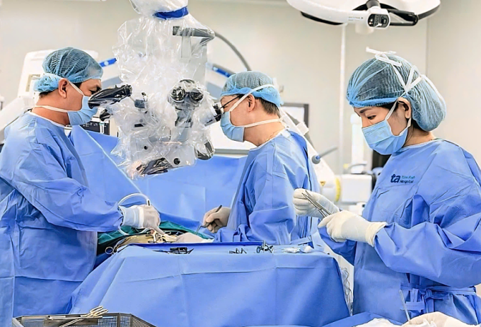 Bác sĩ phẫu thuật lấy u và cắt dây tủy tận cùng cho bà Trân với sự hỗ trợ của kính vi phẫu AI. Ảnh: Bệnh viện Đa khoa Tâm Anh