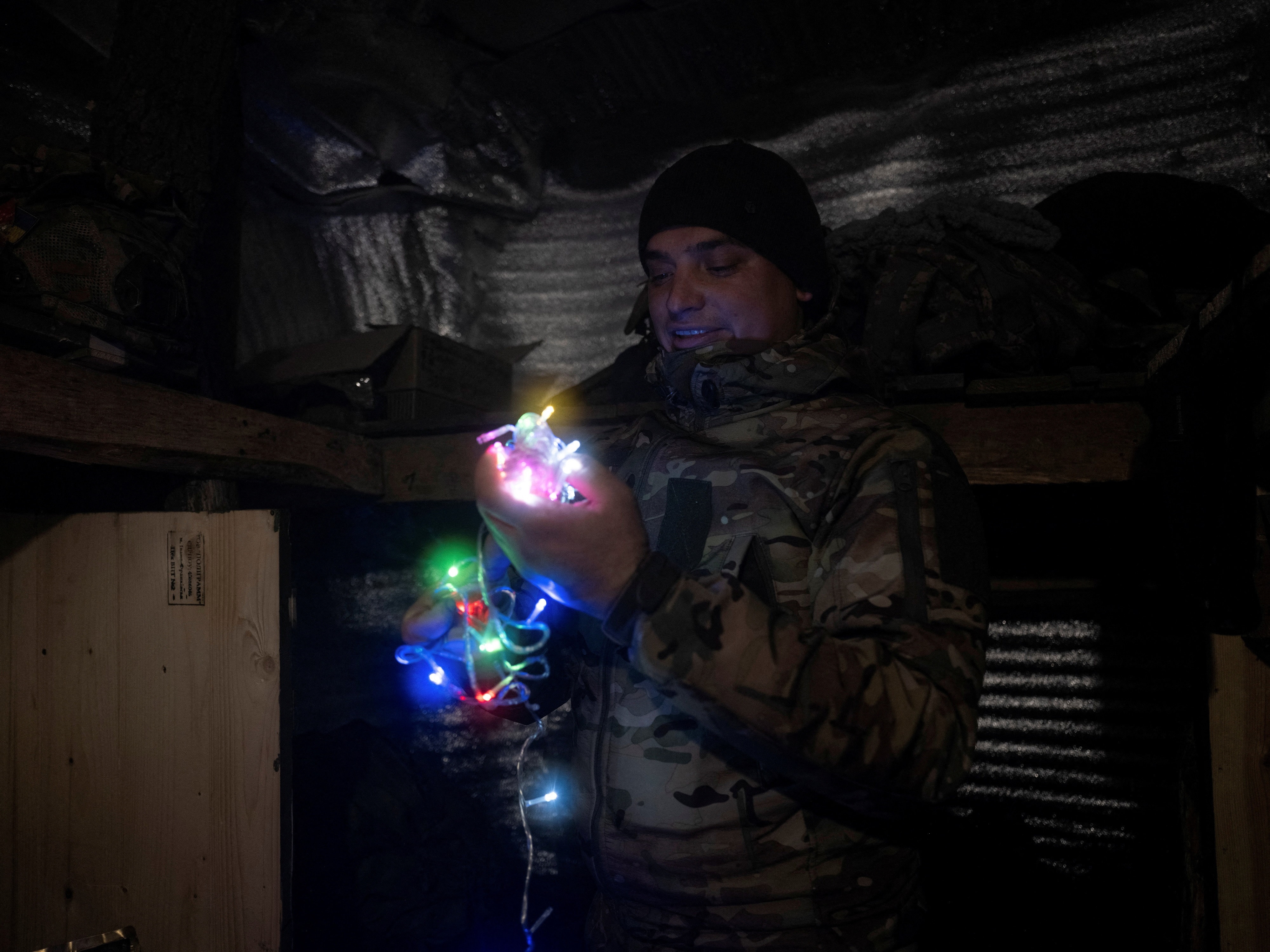 Một binh sĩ Ukraine trang trí hầm trú ẩn bằng đèn đón năm mới tại một vị trí gần thị trấn tiền tuyến Kostiantynivka. (Ảnh: Reuters)