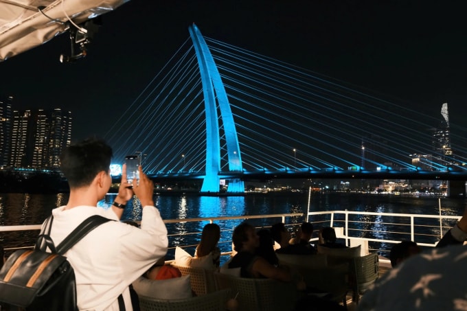 Du khách trải check in khung cảnh hai bên bờ sông Sài Gòn trên buýt sông. Ảnh: Mai Trung
