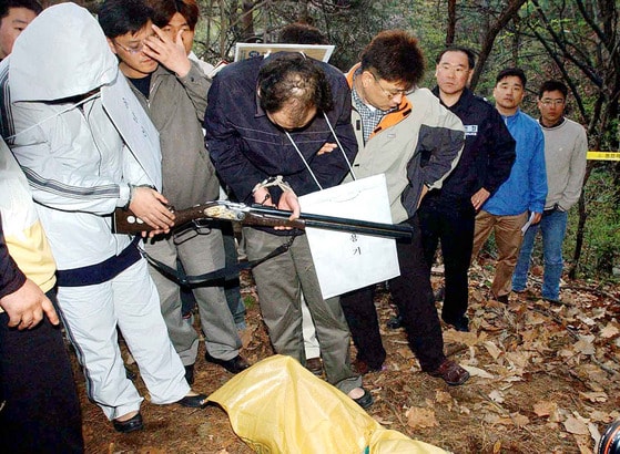 Kim Yong-ki and Yoon Nam-shin, Ha Ji-hyes killers, demonstrate the killing on a mountain in Hanam, Gyeonggi, on April 15, 2003. [JOONGANG ILBO]