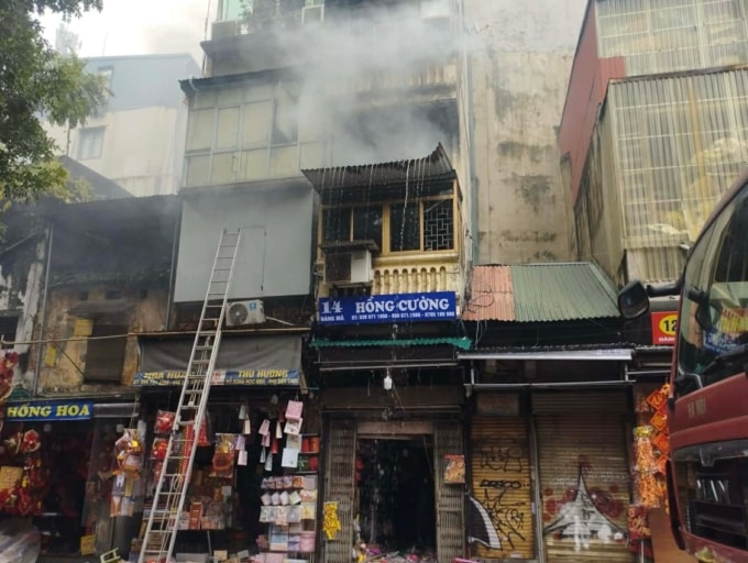 Khói bốc lên từ tầng 2 ngôi nhà trên phố Hàng Mã sáng 31/12. Ảnh: Phạm Chiểu.