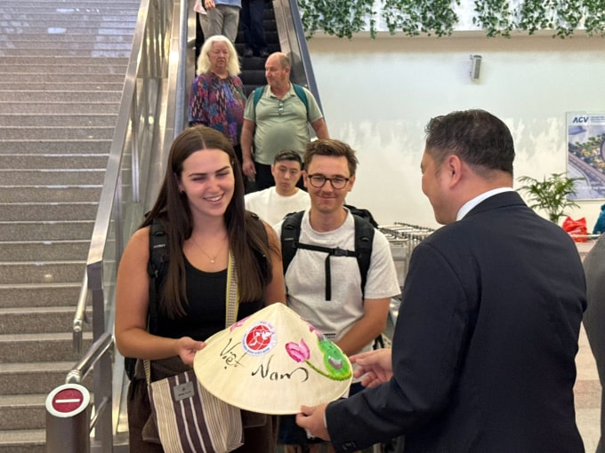 Khách quốc tế được tặng quà khi tới sân bay Tân Sơn Nhất sáng 1/1. Ảnh: Sở Du lịch TP HCM