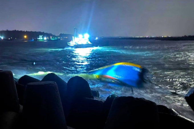 Chiếc tàu gỗ bị sóng đánh chìm dạt vào bờ kè La Gi khi đang vào cửa biển, tối 2/1. Ảnh: Bình Tuy