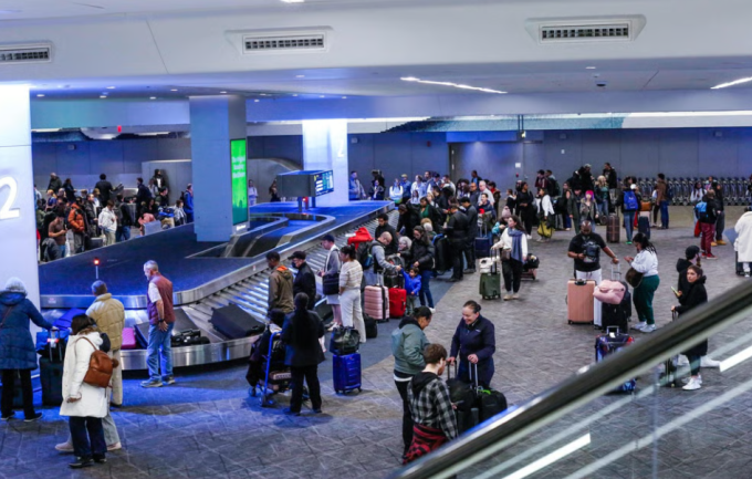 Hành khách chờ nhận hành lý tại sân bay La Guardia, New York, ngày 23/12/2025. Ảnh: AFP