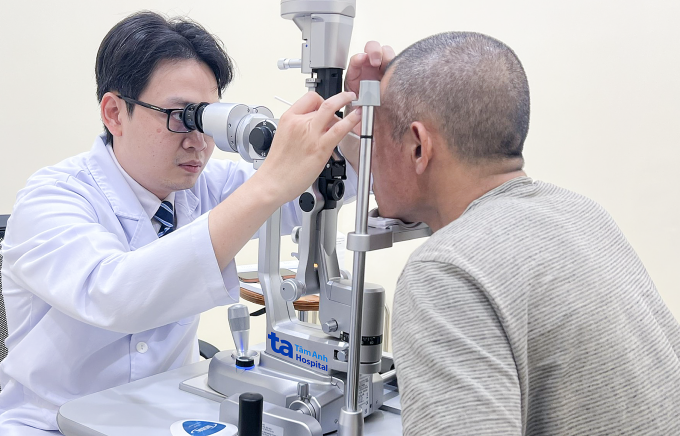 Bác sĩ Huy nhìn qua đèn khe, dùng que bông vô trùng lấy dị vật ra khỏi mắt anh Phong. Ảnh: Bệnh viện Đa khoa Tâm Anh