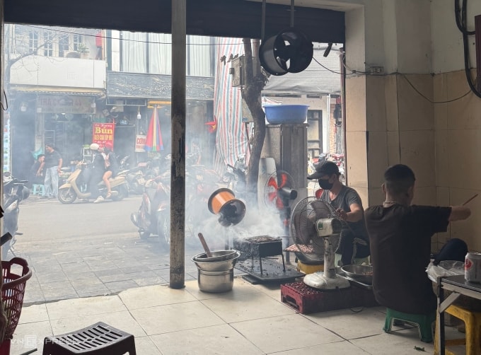 Một quán bún chả trên phố Hàng Buồm, phường Hoàn Kiếm dùng bốn quạt đẩy khói nướng thịt ra ngoài đường, ngày 26/12. Ảnh: Quỳnh Nga