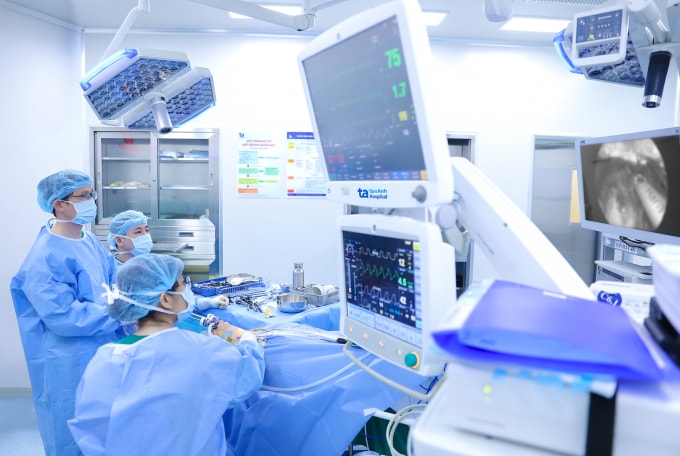 Bác sĩ Tấn (giữa) và êkíp đang phẫu thuật nội soi cho chị Hòa. Ảnh: Trung Vũ