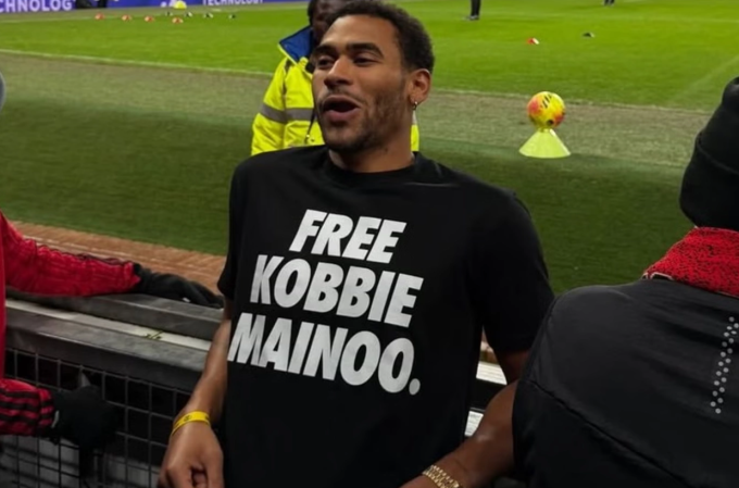 Jordan Mainoo-Hames xuất hiện trên khán đài Old Trafford với chiếc áo in dòng chữ Free Kobbie Mainoo. Ảnh: PA