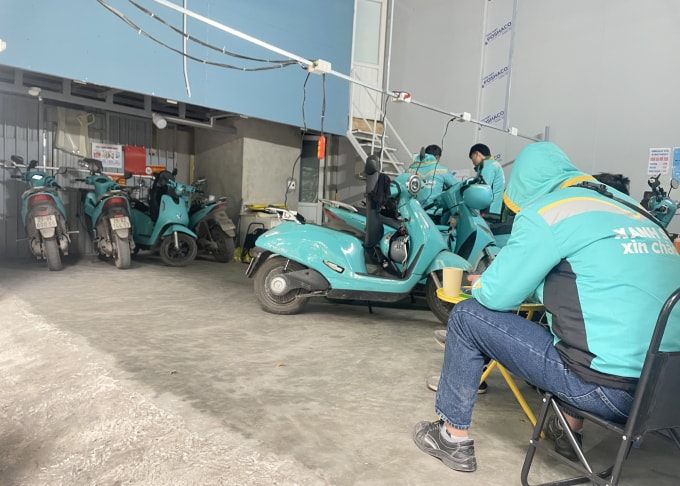 Tài xế ăn uống, nghỉ ngơi trong khi chờ sạc xe tại một trạm ở Vạn Phúc, Hà Nội chiều 6/1. Ảnh: Phan Dương