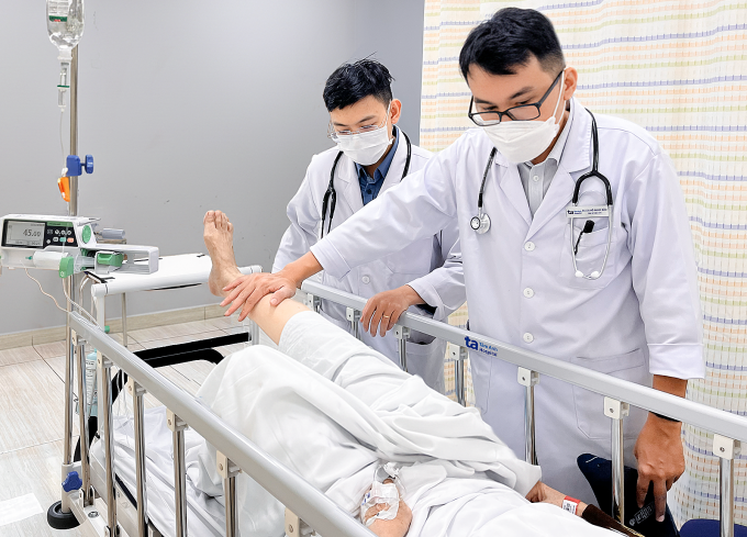Bác sĩ Bảo (phải) khám và đánh giá sức cơ của bà Tiên sau 15 phút dùng thuốc tiêu sợi huyết. Ảnh: Bệnh viện Đa khoa Tâm Anh