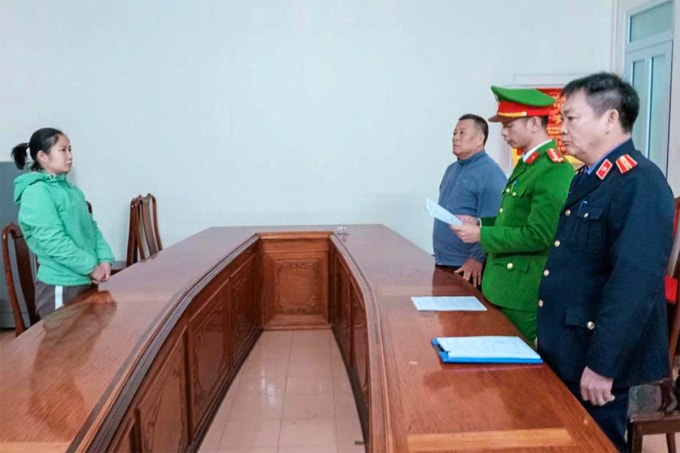 Nghi can Hà (góc trái), nghe cảnh sát đọc lệnh khởi tố. Ảnh: VKS cung cấp