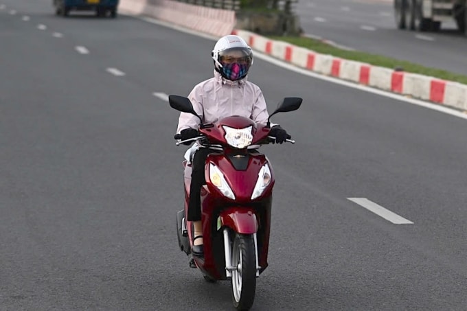 Người dân mặc áo khoác, đeo găng tay lái xe qua cầu Rạch Chiếc, phường Thủ Đức trong trời se lạnh sáng 8/1. Ảnh: Đình Văn