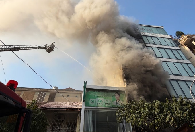 Lực lượng chức năng dùng xe thang phun nước để dập đám cháy. Ảnh: Huy Mạnh