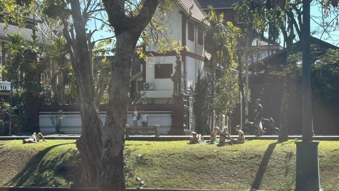 Du khách nước ngoài mặc bikini ngồi và nằm trên bãi cỏ trước ngôi chùa ở Chiang Mai. Ảnh: Expose Chiang Mai V2