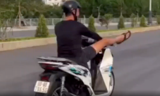 Thanh niên dùng chân điều khiển xe máy. Ảnh: Người dân cung cấp