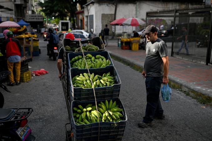 Một người đẩy xe chất đầy chuối ở Caracas, Venezuela ngày 13/11. Ảnh: AFP