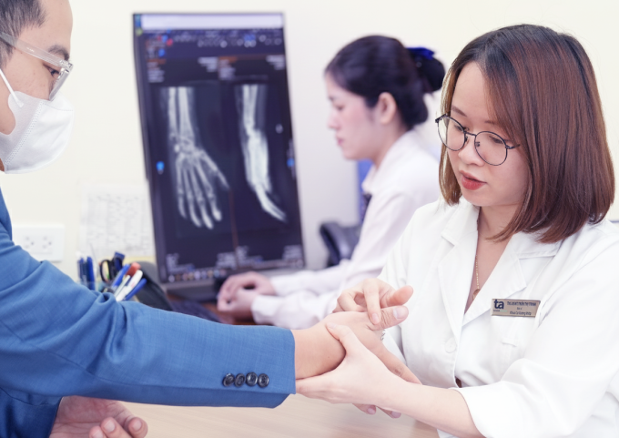 Bác sĩ Trinh khám cho người bệnh đau khớp bàn ngón tay. Ảnh: Bệnh viện Đa khoa Tâm Anh