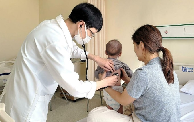 Bác sĩ Hoàng Minh Tiến khám cho bệnh nhi. Ảnh: Hải Âu