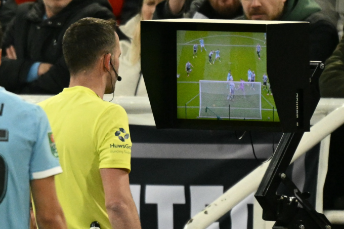 Sau khi VAR mất vài phút kiểm tra tình huống, trọng tài chính Chris Kavanagh ra đường biên xem lại băng hình rồi mới thông báo không công nhận bàn của Man City. Ảnh: AFP
