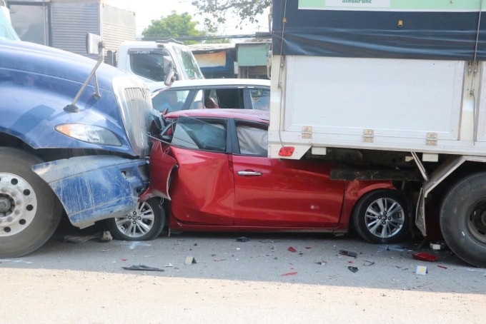 Xe 4 chỗ bị kẹp giữa xe tải và container sau tai nạn liên hoàn. Ảnh: Trường Hà