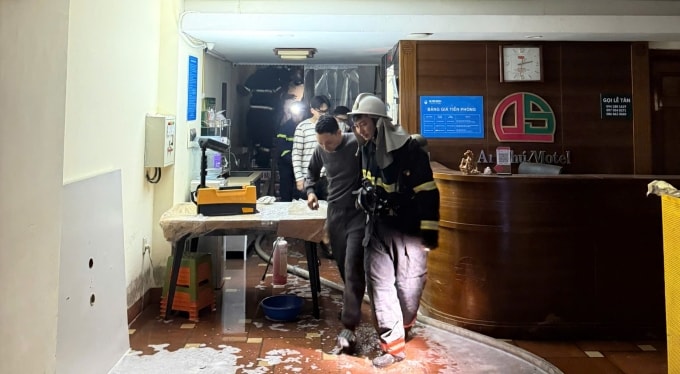 Cảnh sát phòng cháy đưa người bị kẹt khỏi đám cháy ra ngoài. Ảnh: Hồng Việt