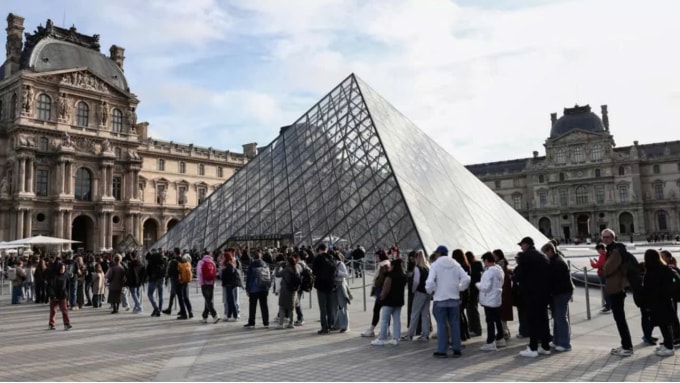 Khách xếp hàng đợi vào cổng trước Bảo tàng Louvre. Ảnh: AFP