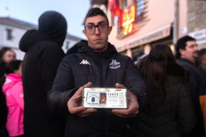 Một người dân làng Villamanín khoe tấm vé trúng độc đắc hôm 22/12/2025. Ảnh: El Pais
