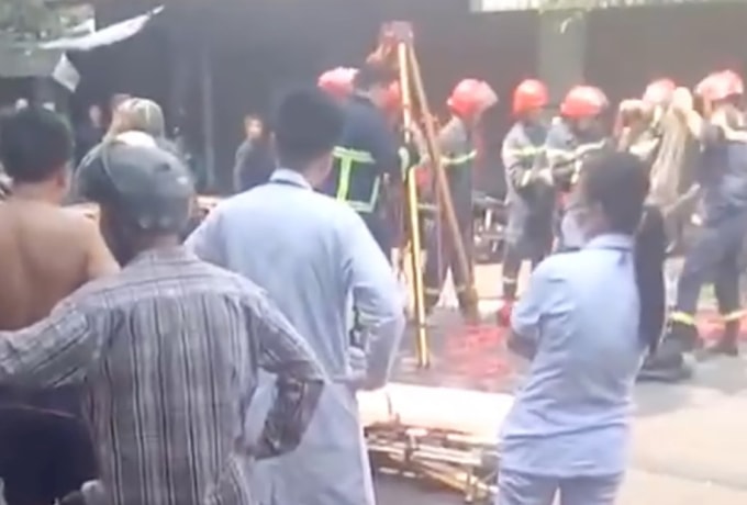 Lực lượng cứu hộ đưa hai nạn nhân ra khỏi hố ga. Ảnh: Người dân cung cấp