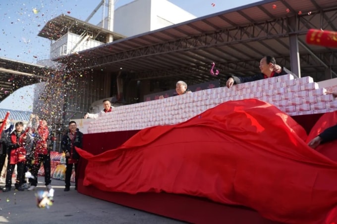 Từng cọc tiền nhân dân tệ mệnh giá 100 đồng xếp chồng trên chiếc bàn dài phủ khăn đỏ tại công ty Nông nghiệp Xanh ở tỉnh Giang Tây ngày 9/1. Ảnh: China News